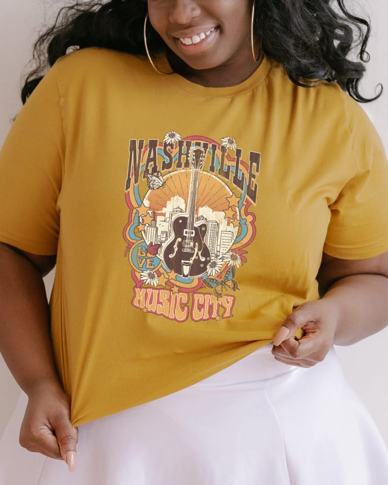 Front of a model wearing a size XL Music City Flowers in Mustard by Simply Sage Market. | dia_product_style_image_id:281533